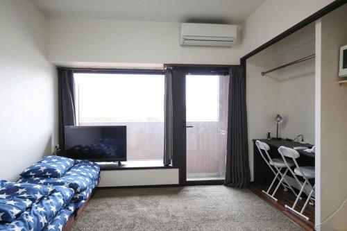 a bedroom with a bed and a desk and a window at SUMIYOSHI APARTMENT Hotel 住吉アパートメントホテル in Fukuoka
