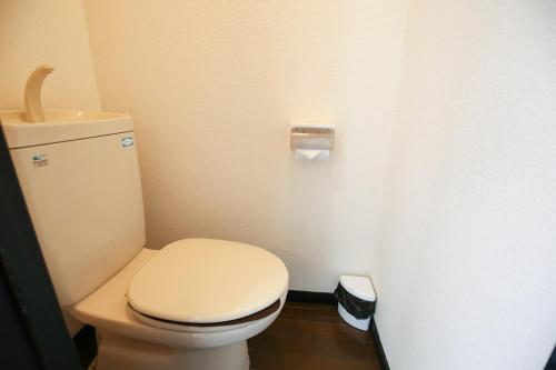 a bathroom with a toilet with a toilet paper dispenser at SUMIYOSHI APARTMENT Hotel 住吉アパートメントホテル in Fukuoka
