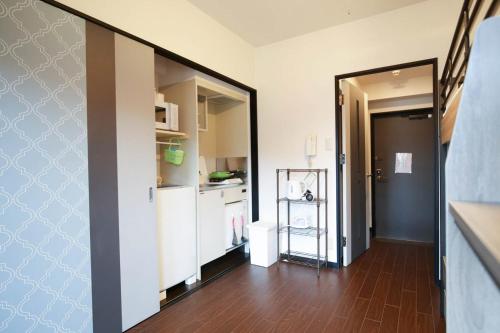 a room with a kitchen and a hallway with a mirror at SUMIYOSHI APARTMENT Hotel 住吉アパートメントホテル in Fukuoka