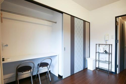 two chairs sitting next to a partition in a room at SUMIYOSHI APARTMENT Hotel 住吉アパートメントホテル in Fukuoka