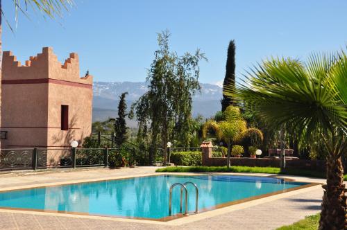 uma piscina em frente a uma casa com um castelo em Le Beau Site Ourika em Aghmat