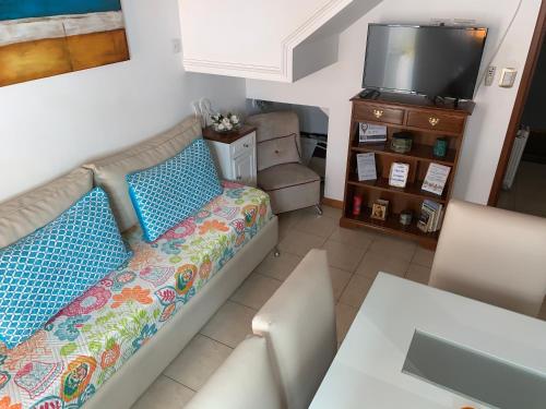 a living room with a bed and a television at Casamia Altos in Bahía Blanca