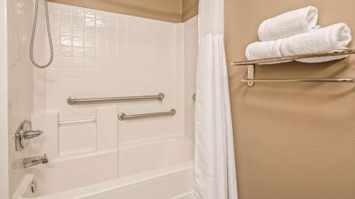 a bathroom with a tub and a shower with towels at Best Western Gateway Inn in Yazoo City