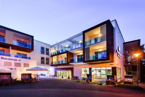 a building with chairs and tables in front of it at Best Western Hotel Jurata in Jurata