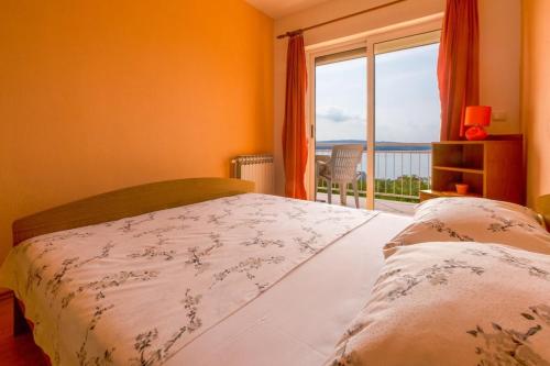 a bedroom with a bed and a window with a view at Two-Bedroom Apartment in Crikvenica XII in Dramalj