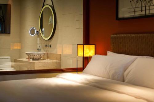 1 dormitorio con lavabo, cama y espejo en Phuket Panwa Beachfront Resort, en Panwa Beach