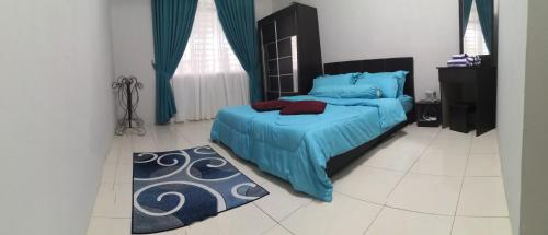 a bedroom with a blue bed and a rug at Zumara Homestay Jerantut Pahang in Jerantut
