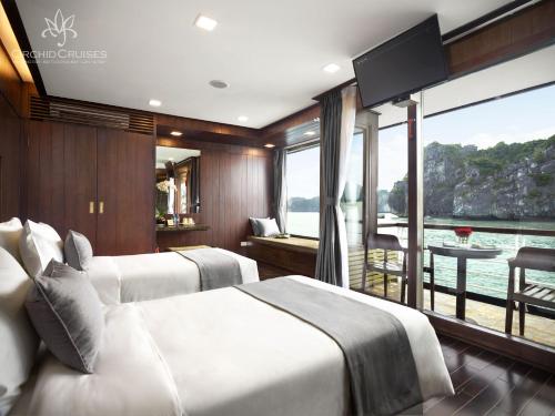 a bedroom with two beds and a view of the water at Orchid Classic Cruise in Ha Long