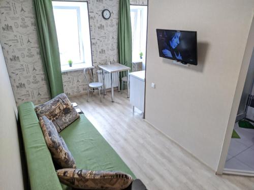 オムスクにあるКАСКAД аpartment na Karla Marksa 2-х комнатная квартираのリビングルーム(ソファ、壁掛けテレビ付)
