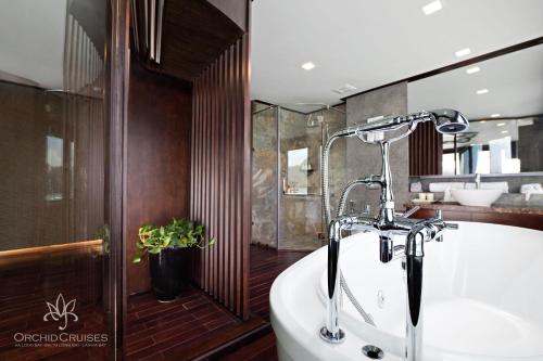 a bathroom with a bath tub and a sink at Orchid Classic Cruise in Ha Long