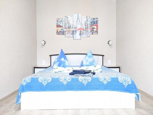 オムスクにあるКАСКAД аpartment na Karla Marksa 2-х комнатная квартираのベッドルーム1室(青と白のベッド、青の枕付)