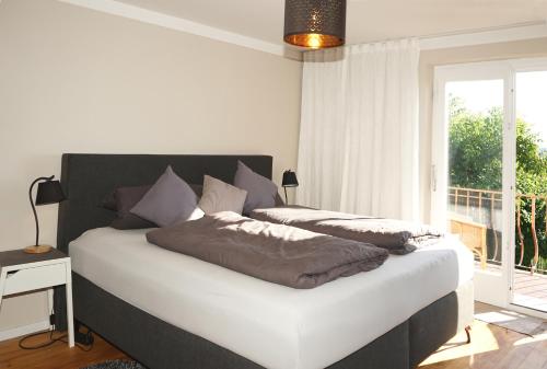 a bedroom with two beds and a large window at Haus Bregenz Apartment Bodensee in Lochau