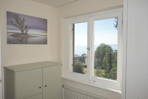a white kitchen with two windows and a view of the water at Haus Bregenz Apartment Bodensee in Lochau