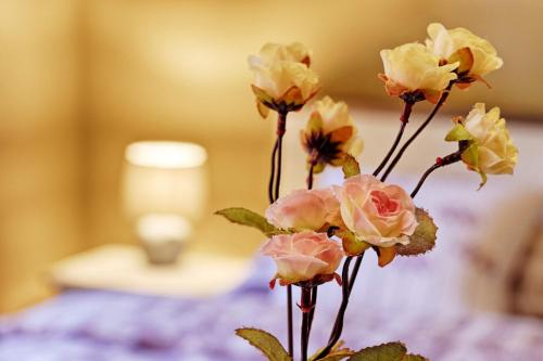 a vase filled with pink roses on a table at Měšťanský dům - kulturní památka Mlýnská 119 in Jindrichuv Hradec