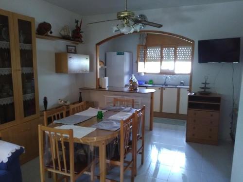 una cucina con tavolo con sedie e frigorifero di Villa Montsià a Sant Carles de la Ràpita
