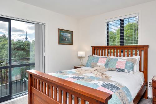a bedroom with a bed and a large window at Greenwich Townhouse with Parking and Air-Con in Auckland