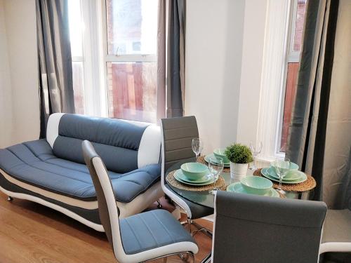 ルートンにあるAshburnham Apartmentのダイニングルーム(青いソファ、テーブル付)