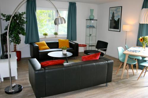 a living room with a black leather couch at Eifel REBEIGE Gerolstein in Kopp