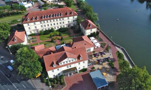 a small town with houses and boats on the water at Hotel Stadt Hameln in Hameln