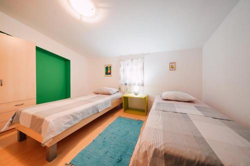 1 Schlafzimmer mit 2 Betten und einer grünen Tür in der Unterkunft Two-Bedroom Apartment in Ljubac I in Krneša