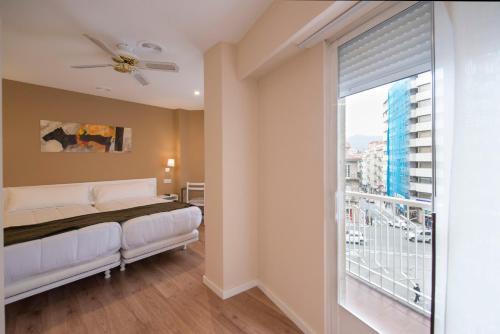 ein Schlafzimmer mit einem Bett und einem großen Fenster in der Unterkunft Hotel Miño in Ourense