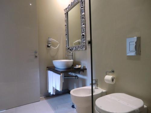 a bathroom with a sink and a toilet and a mirror at B&Beach Cagliari guest house in Cagliari