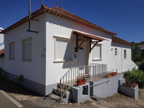 a white house with a porch and a door at Casa 4 Estaçoes in Batalha