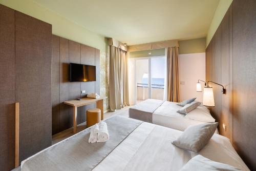 a hotel room with two beds and a television at Hotel Life in Rimini