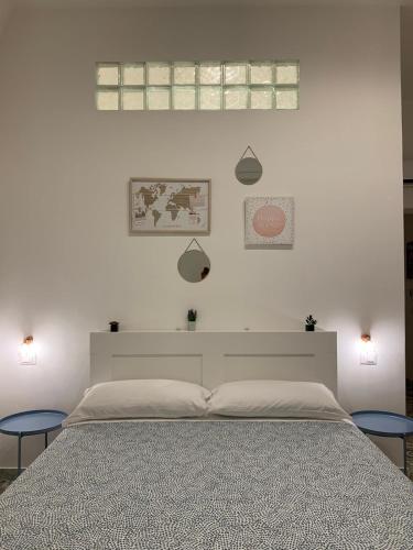 a white bedroom with a large bed with two chairs at AllYouCanTrip - La Nova in Naples