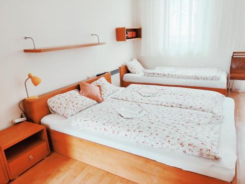 two twin beds in a room with a night stand at Apartmán 302 Oščadnica in Oščadnica
