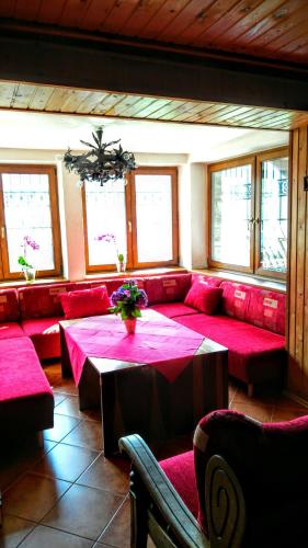 a living room with red couches and a table with flowers at Horská chata Kouty in Loučná nad Desnou