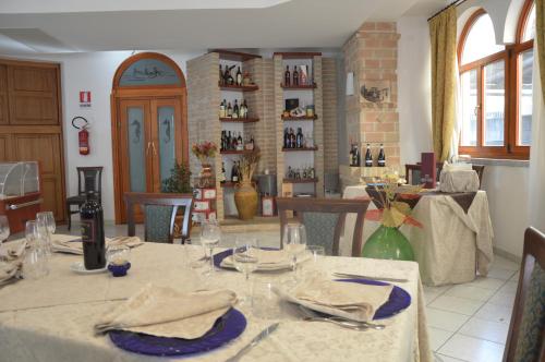 a dining room with a table with plates and wine glasses at Hotel Ristorante Antica Marina in Nicotera Marina