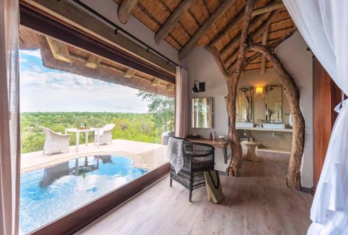an indoor pool in a house with a large window at Leopard Hills Private Game Reserve in Sabi Sand Game Reserve