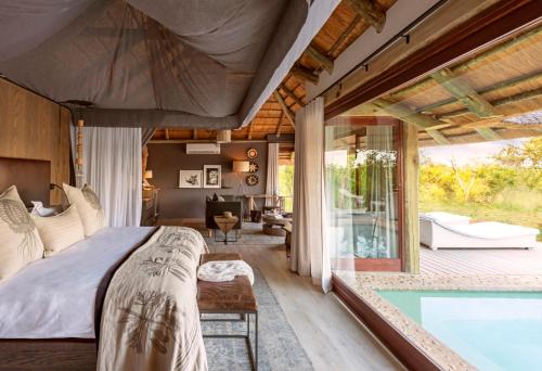 a bedroom with a bed and a swimming pool at Leopard Hills Private Game Reserve in Sabi Sand Game Reserve