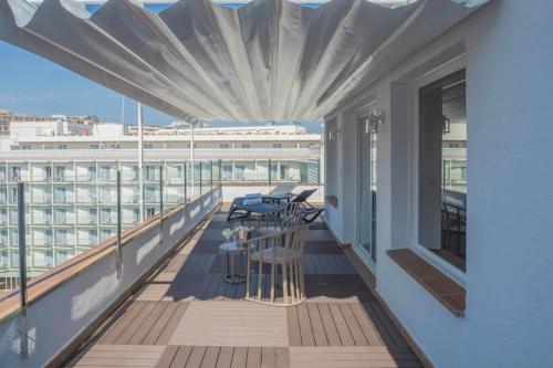 a balcony with chairs and a table on a building at Hotel Acapulco in Lloret de Mar