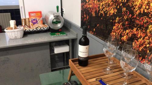 een fles wijn op een tafel met wijnglazen bij Duquesa 32 in Logroño