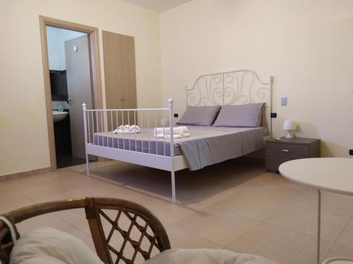 a bedroom with a bed with purple pillows and a table at SICILIA Affitta CAMERE in Ragusa