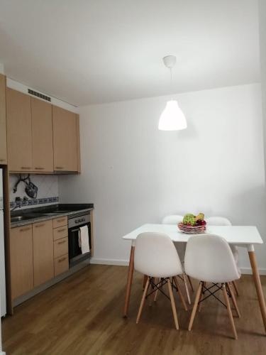 a kitchen with a white table and white chairs at São Roque View Apartment in Aveiro