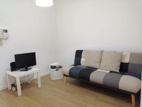 a living room with a couch and a tv at São Roque View Apartment in Aveiro