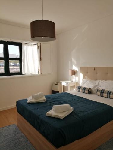 a bedroom with a large bed with two towels on it at São Roque View Apartment in Aveiro