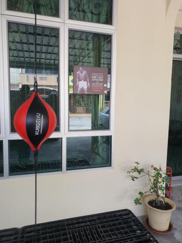a red and black baseball bat hanging in front of a building at UTHM Parit Raja Homestay in Parit Raja