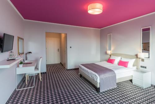 una camera d'albergo con un grande letto e una scrivania di Hotel Sękowski a Legnica