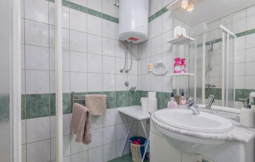 a white bathroom with a sink and a mirror at Apartment Rudika in Klimno