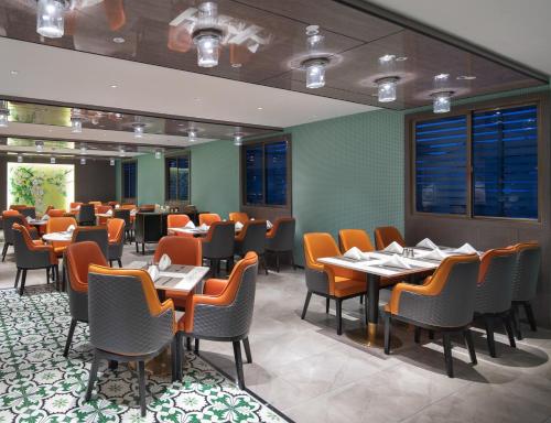 a restaurant with tables and chairs in a room at Kasion Pugis Hotel in Yiwu