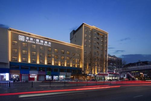 un gran edificio con luces en el lateral de una calle en Kasion Pugis Hotel, en Yiwu