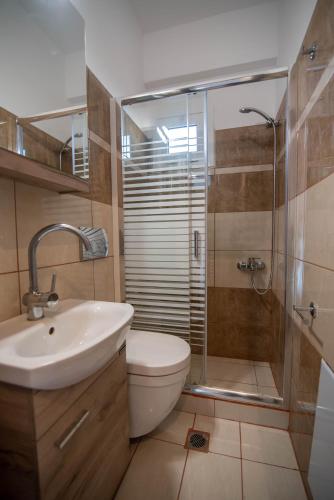 a bathroom with a toilet and a sink and a shower at Kassianis House Mytikas in Kalamitsi