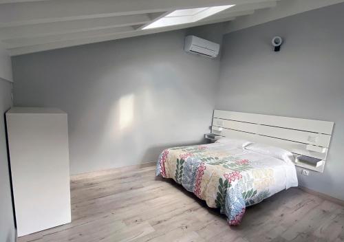 a bedroom with a bed in a white room at La Fragua in Santillana del Mar