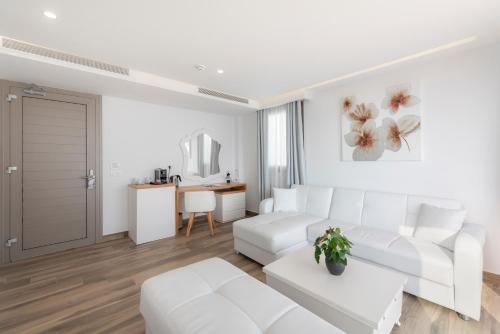 a white living room with a white couch and a table at White Rock of Kos Hotel - Adults only in Kefalos