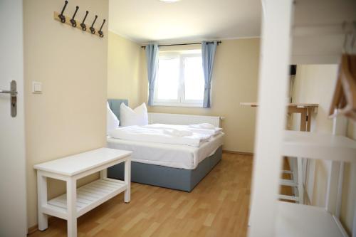 a small bedroom with a bed and a window at Pension Elfmeter in Rheinsberg