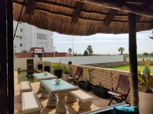 a patio with tables and chairs on a roof at Palm Beach Guesthouse in Port Elizabeth